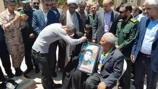 اهدا یک مدل طلا و مدال برنز به پدر و مادر شهید توسط قهرمان بسیجی شهرستان البرز