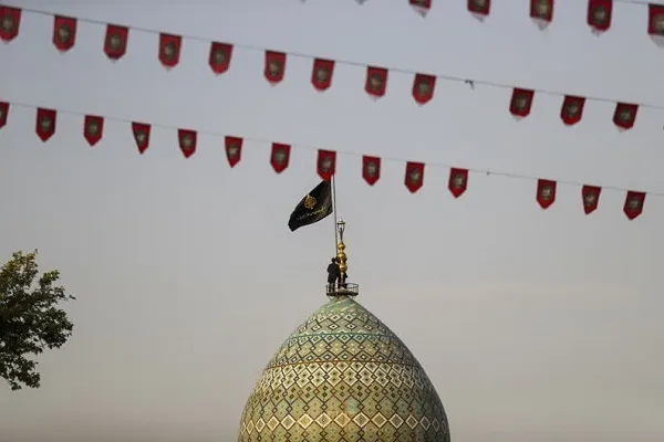 اهتزاز پرچم عزای حسینی بر فراز گنبد حرم شاهچراغ