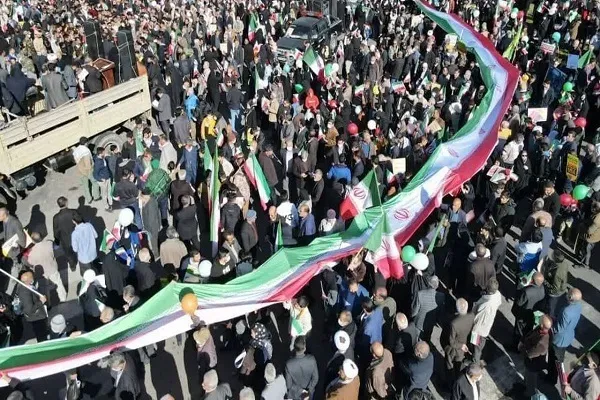 حمل پرچم ۶۰ متری توسط ورزشکاران با لباس‌های ورزشی در طول مسیر راهپیمایی شیراز